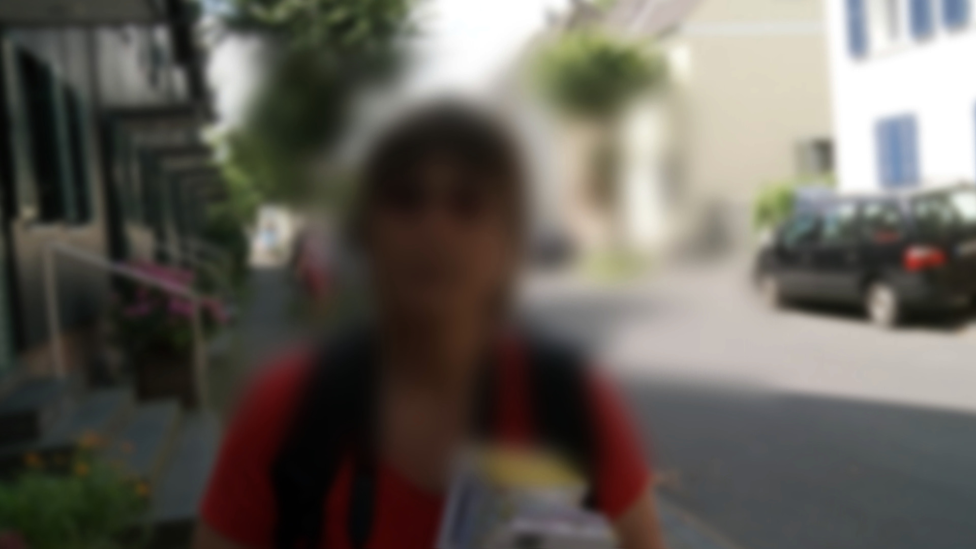 In der Mitte unscharfes Portrait einer Frau auf einer Straße.